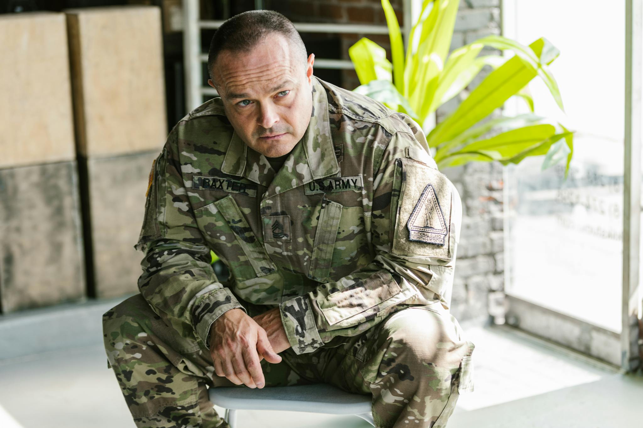 Focused Army Soldier Sitting Indoors In Military