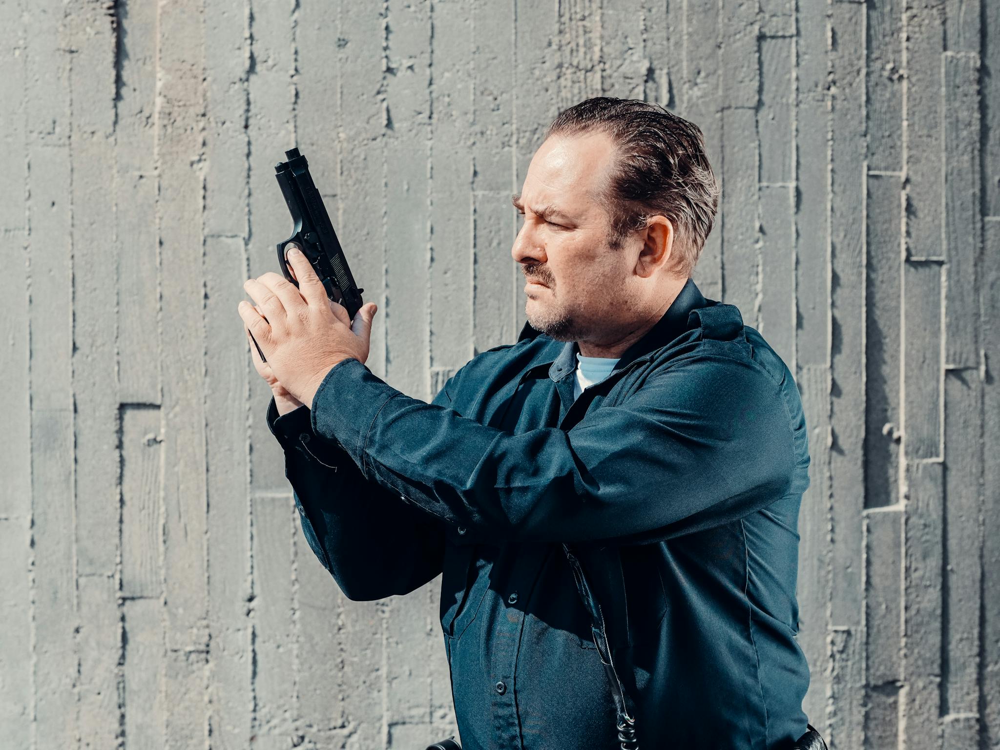 Officer Standing Against A Concrete Wall Securing